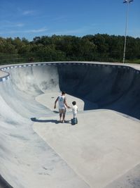 Rear view of man with son at skateboard park