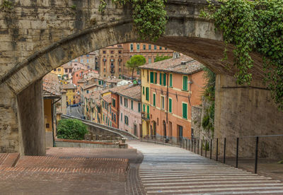 Arch bridge over footpath amidst buildings in town