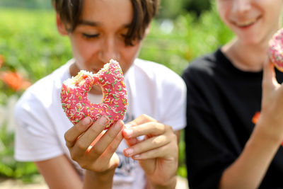 Teenager boys eating doughnuts