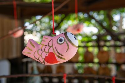 Close-up of heart shape hanging on pink flowers