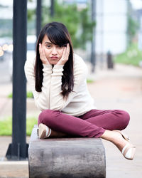 Portrait of young woman sitting in park