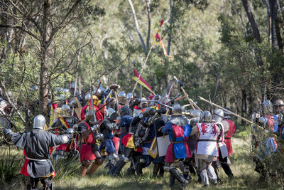 Men fighting on field by tree