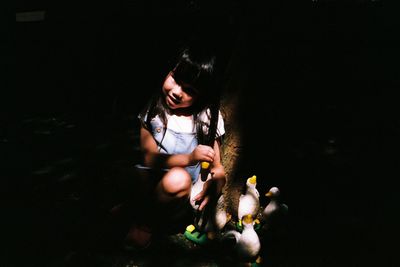 Girl holding toy against black background