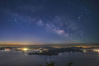 High angle view of illuminated cityscape against sky at night