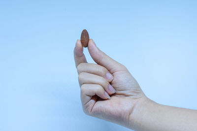 Close-up of person hand against blue background