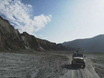 Scenic view of land and mountains against sky