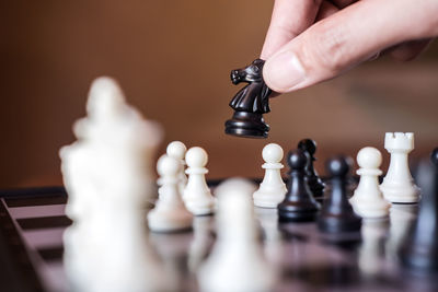 Close-up of man holding chess piece