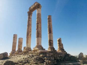 Low angle view of old ruins against clear blue sky