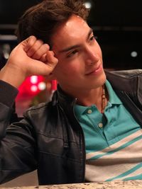 Thoughtful teenage boy looking away while sitting in cafe