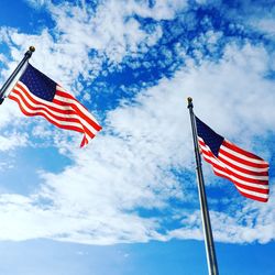 Low angle view of american flags against sky