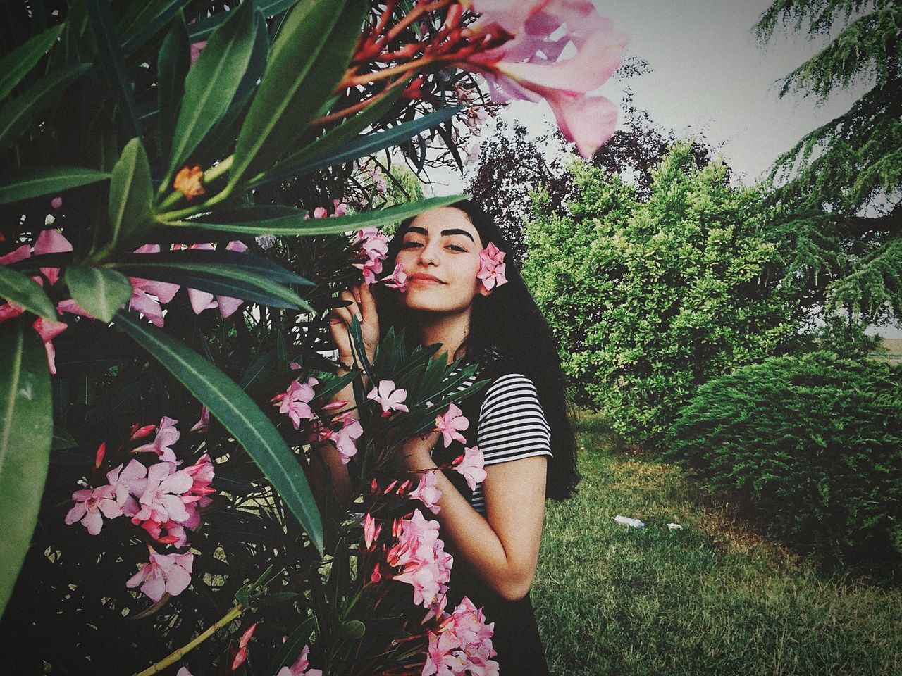 plant, growth, flower, one person, flowering plant, young adult, leisure activity, real people, young women, lifestyles, beauty in nature, nature, standing, fragility, casual clothing, vulnerability, freshness, day, leaf, beautiful woman, outdoors, hairstyle, flower head