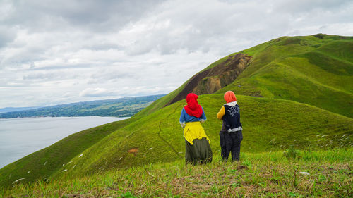 Woman standing on mountain road against sky