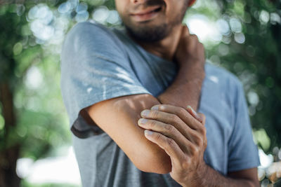 Midsection of man sitting in park