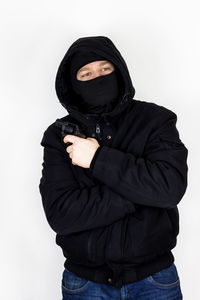 Portrait of young woman standing against white background