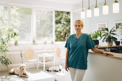 Portrait of confident female veterinarian at reception in veterinary clinic