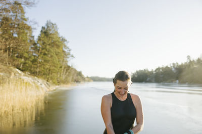 Smiling woman wearing swimwear at river