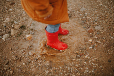 Low section of girl standing in puddle