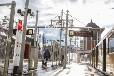 Rear view of woman walking by train at railroad station platform