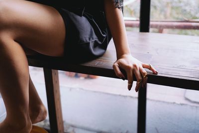 Midsection of woman sitting on bench