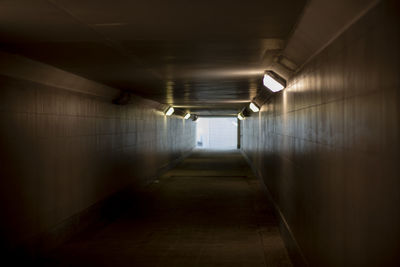 Tunnel with lamps. architecture of city. pedestrian crossing under road. light at end of tunnel.
