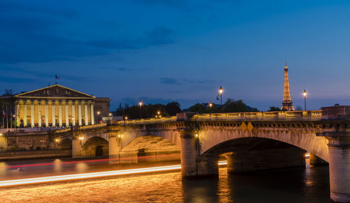 Arch bridge over river at night