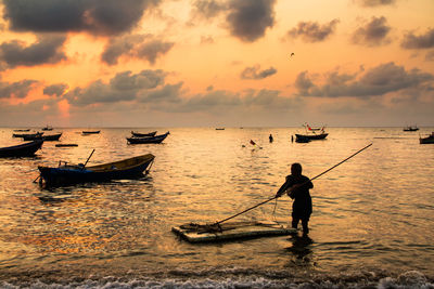 Boat sailing in sea at sunset