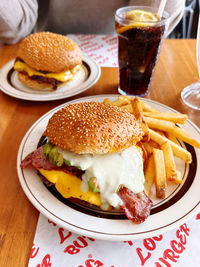 High angle view of burger with french fries in plate on table