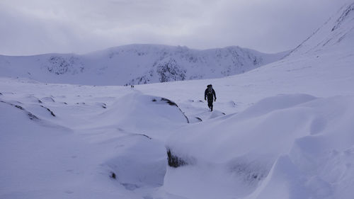 People on snow covered mountain against sky