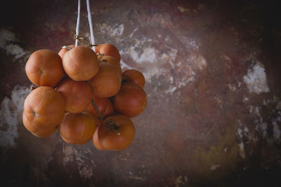 Close-up of tomatoes hanging against wall