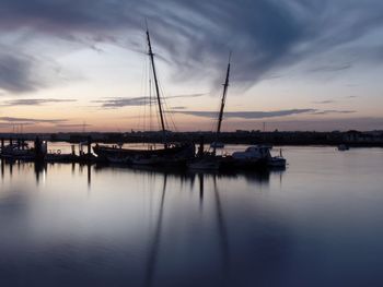 Sailboats in sea at sunset