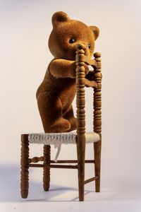 Teddy bear on chair over white background
