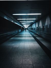 People walking in illuminated underground walkway