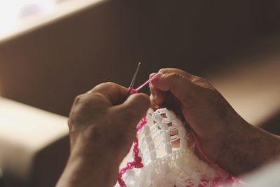 Cropped hands of person weaving wool