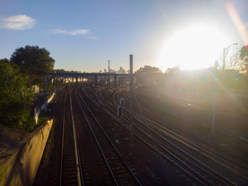 Railroad tracks against sky during sunset