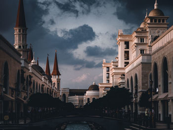 Buildings in city against cloudy sky