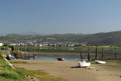 Sailboats moored on beach against clear sky