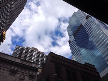 Low angle view of modern building against cloudy sky