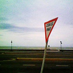 Low angle view of road sign against sky