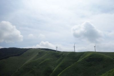 Wind turbines on land against sky