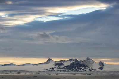 Scenic view of snowcapped mountains against sky during sunset