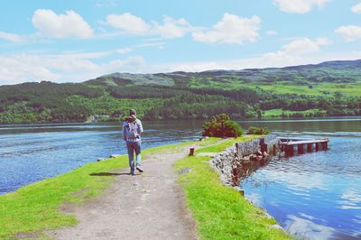 Rear view of person on lake against sky