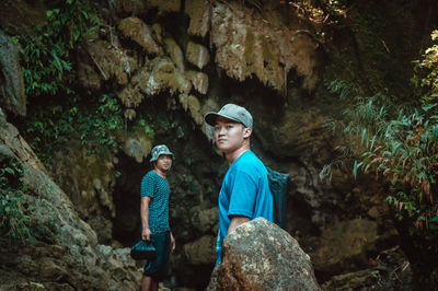 Side view portrait of male hikers standing against rock formations