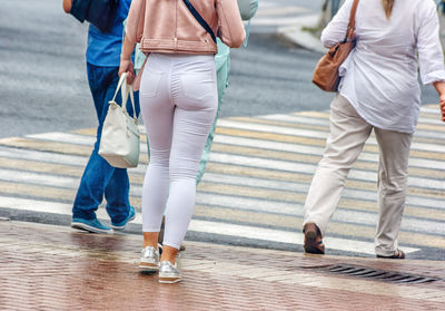 Low section of people crossing street in city