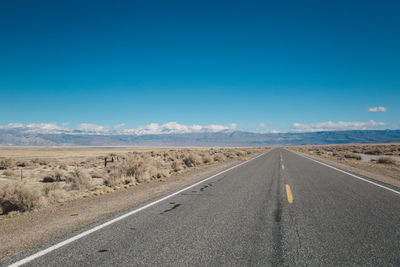 Road against clear blue sky