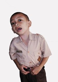 Portrait of boy standing against white background