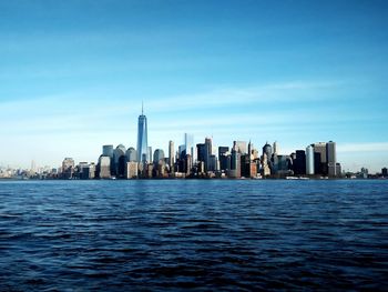 Cityscape by hudson river against sky