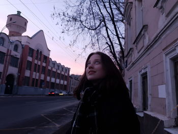 Young woman standing on road in city