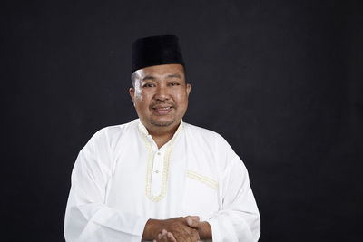 Man standing against black background