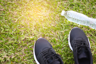 High angle view of shoes and water bottle on grassy field