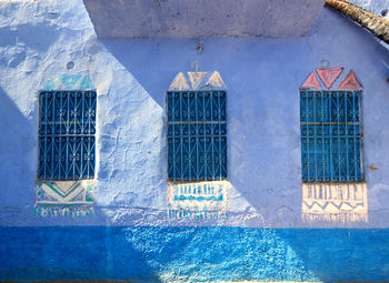 Close-up of metal grate against blue wall